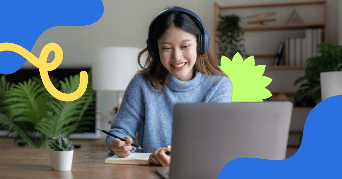 A woman wearing headphones is sitting at her desk completing online training.